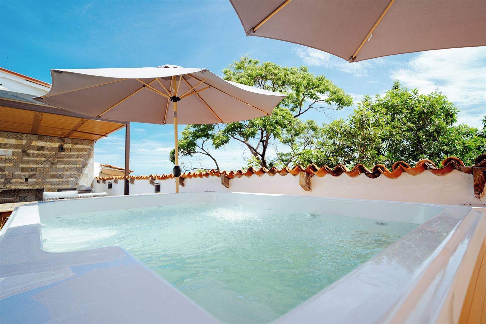 Hotel Casa Kavia: the rooftop hot tub by day, with two umbrellas and tiled walls